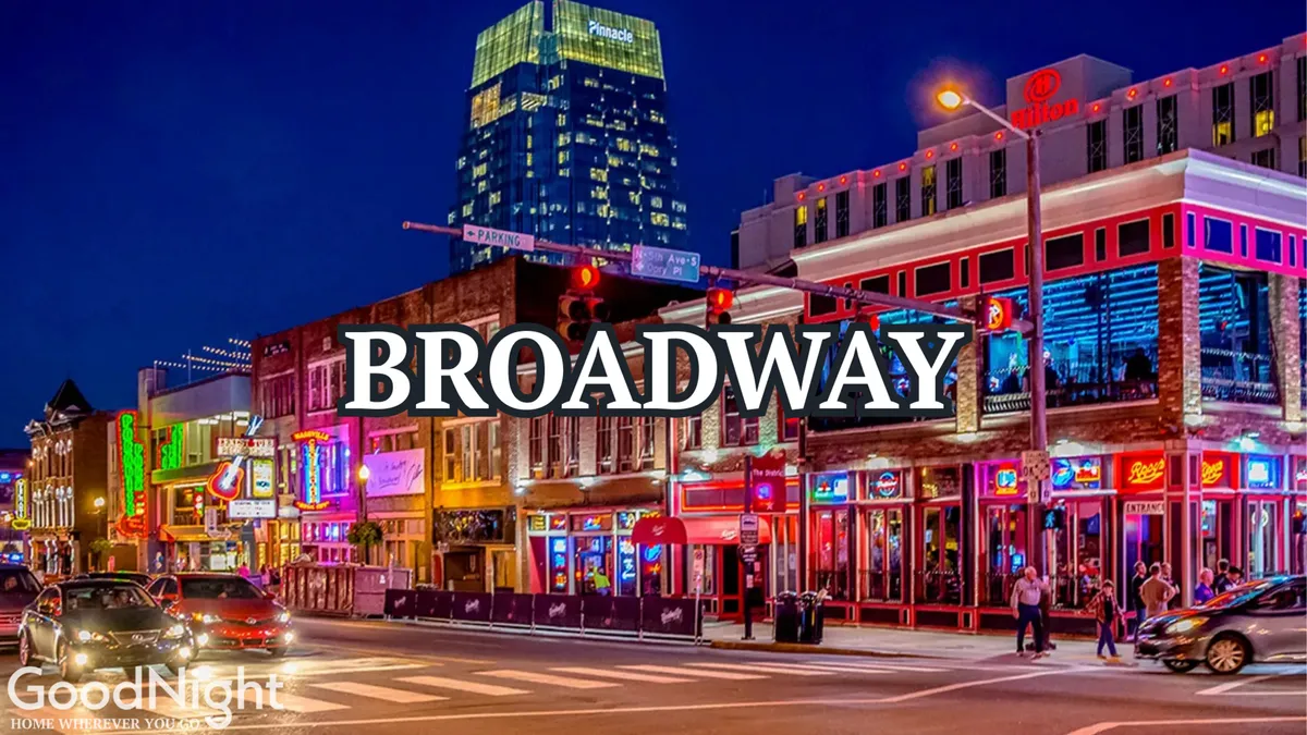 A vibrant nighttime city scene featuring neon signs, traffic lights, people strolling past lively building facades, and a sense of Nashville’s energetic nightlife and dining scene.